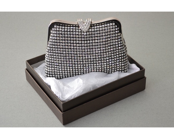 Black clutch bag covered with crystal stones with a 'V' shaped clasp with additional crystals. Long chain included