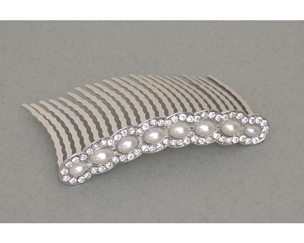 A row of large pearl beads surrounded by crystal stones on a comb