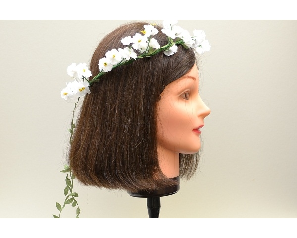 White flower with green twine hair garland on circular band.