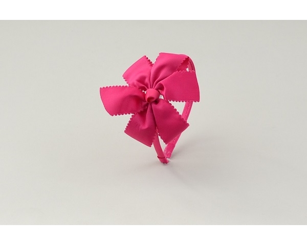 Sateen covered alice band with side mounted fabric bow in tones of pink as per images.